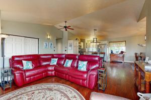 a red leather couch in a living room at Salty Sunsets in Depoe Bay