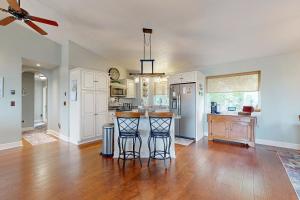 a kitchen with white cabinets and a hard wood floor at Salty Sunsets in Depoe Bay +26 photos