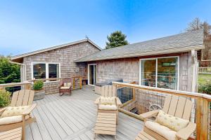 a deck with chairs and chairs on a house at Salty Sunsets in Depoe Bay