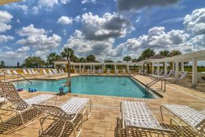 a swimming pool with lounge chairs and a resort at Pet-Friendly Home with Golf Cart in The Villages! in Lady Lake
