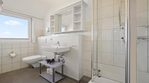 a bathroom with a toilet and a sink and a shower at Gurtdeel Meer Blick-Suite in Hörnum