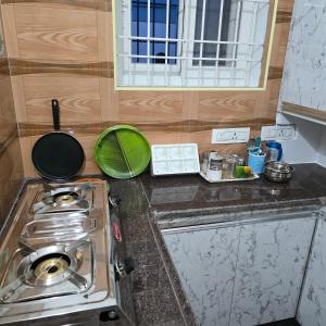 a kitchen counter with a stove and a window at Padmini's home stay New apartment 2bhk in Tirupati