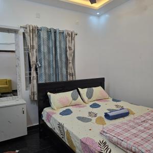 a bedroom with a bed with a blanket and a window at Padmini's home stay New apartment 2bhk in Tirupati