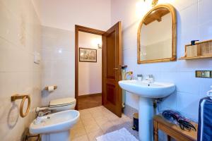 a bathroom with a sink and a toilet and a mirror at Casa Bruna - 100m dal Lago Maggiore in  Monvalle 