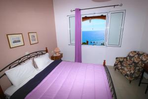 ein Schlafzimmer mit einem Bett und einem Fenster mit Blick auf das Meer in der Unterkunft Villa Takis - Kontogialos, Pelekas Beach in Pelekas