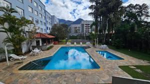 una piscina al centro di un edificio di Retiro dos Sonhos – Piscina, Jacuzzi e Sauna na Montanha a Teresópolis