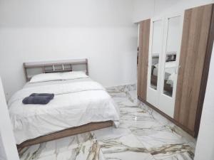 a bedroom with a bed and a marble floor at Snz Guesthouse in Port Louis