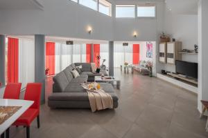 salon z szarą kanapą i czerwonymi krzesłami w obiekcie Villa Brcina w Puli +37 zdjęć