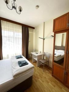 a bedroom with a bed and a desk and a mirror at Deniz pansiyon in Akcakoca