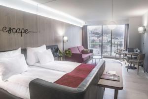 a bedroom with a large bed and a living room at Hotel Norge by Scandic in Bergen