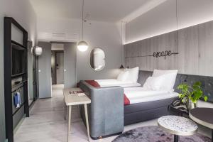 a hotel room with a couch and a tv at Hotel Norge by Scandic in Bergen