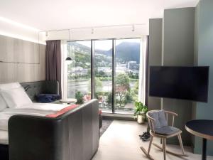 a hotel room with a bed and a large window at Hotel Norge by Scandic in Bergen
