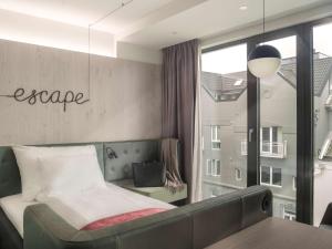 a bedroom with a bed and a table and a window at Hotel Norge by Scandic in Bergen