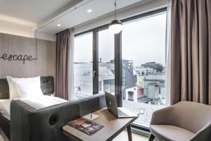 a bedroom with a bed and a desk with a laptop at Hotel Norge by Scandic in Bergen