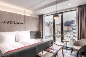 a hotel room with a bed and a large window at Hotel Norge by Scandic in Bergen