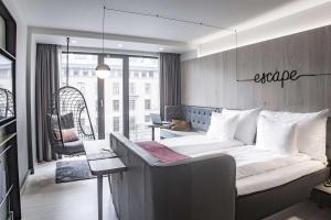 a bedroom with a large bed and a living room at Hotel Norge by Scandic in Bergen