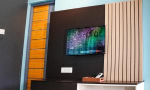 a flat screen tv hanging on a wall at H2cottage in Wodapatti