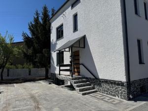 a white building with stairs leading up to a door at Apartments 52 in Biała Podlaska