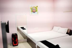 a white room with two beds and a mirror at H2cottage in Wodapatti