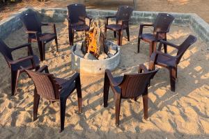 a group of chairs sitting around a fire pit at H2cottage in Wodapatti