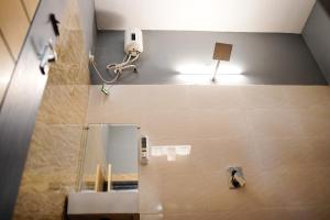 a bathroom with a mirror and a light on the wall at H2cottage in Wodapatti