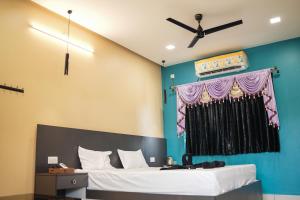 a bedroom with a bed with a ceiling fan at H2cottage in Wodapatti