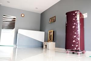 a living room with a refrigerator and a wall at H2cottage in Wodapatti
