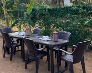 a wooden table and chairs in a yard at H2cottage in Wodapatti