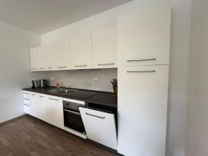 a kitchen with white cabinets and a black counter top at Residence San Francesco in Tirrenia