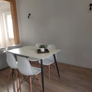 ein weißer Tisch und Stühle mit einer Pflanze drauf in der Unterkunft Le refuge du lac in La Tessoualle