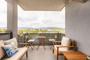 Un balcón con sillas y mesas y vista a una ciudad. en Eurorail logistics Apartment, en Zagreb