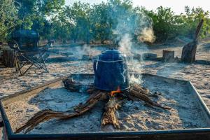 a blue pot sitting on top of a fire at African Excursions Guest lodge in Khwai