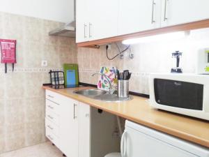 a kitchen counter with a microwave and a sink at Alcantara Quiet & Calm in Lisbon in Lisbon