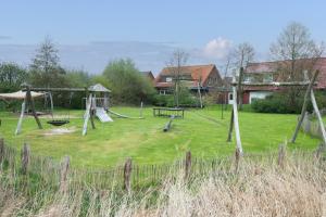 a playground with a swing set in a yard at Watt'n Mehr in Krummhörn