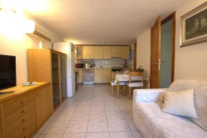 a living room with a couch and a kitchen at GuestHost - Sonja's Home Dolianova in Dolianova