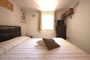 a bedroom with a bed with a pillow on it at GuestHost - Sonja's Home Dolianova in Dolianova