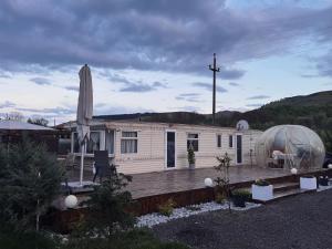 克卢日-纳波卡Kinder Valley Morlaca Cluj的一栋带有透明穹顶、位于木质甲板上的房子