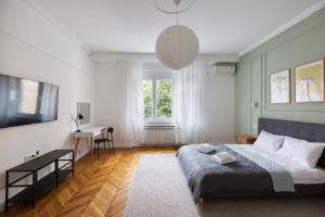 a bedroom with a bed and a desk and a window at High Note Suites in Belgrade