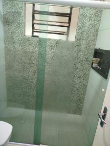 a bathroom with a shower with a glass door at Chácara 2 irmãos in São Pedro