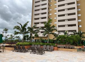 a patio with chairs and tables in front of a building at Hot Beach Suites in Olímpia