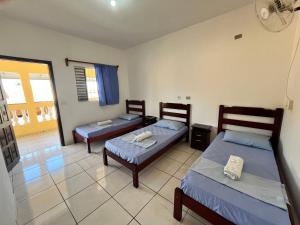 a bedroom with two beds and a balcony at Polis Hotel in Pindamonhangaba +8 photos