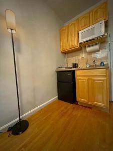 Una pequeña cocina con un refrigerador negro y una lámpara. en Chelsea Studio 5 - Shared Bathroom, en Nueva York