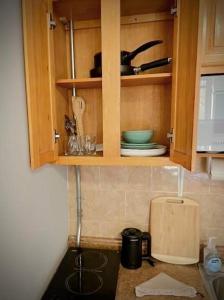 Una cocina con gabinetes de madera y encimera. en Chelsea Studio 5 - Shared Bathroom, en Nueva York