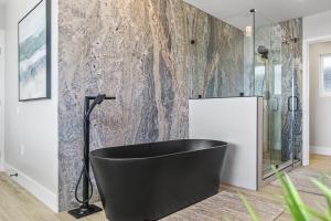 a black bath tub in a bathroom with a wall at Tower 9 in Oceanside +42 photos