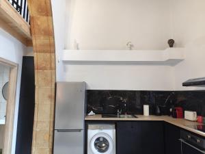 eine Küche mit einem Kühlschrank und einer Waschmaschine in der Unterkunft Lindos Central in Lindos