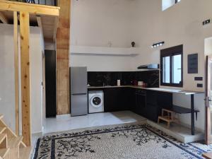 eine Küche mit schwarzen Schränken und einer Waschmaschine und einem Trockner in der Unterkunft Lindos Central in Lindos