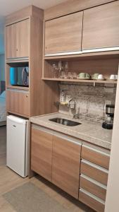 ペドラ・アズールにあるFlat Vista Azul Hotelのシンクと電子レンジ付きのキッチン