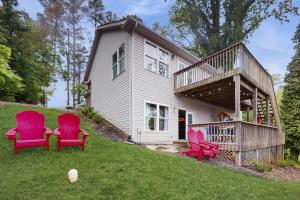 three red chairs sitting on the grass in front of a house at Wet Feet Retreat in Moneta