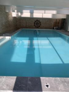 a swimming pool with blue water in a building at Parfums de Monet in Saint-Illiers-le-Bois