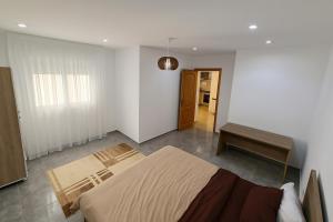 a bedroom with a bed and a bench in it at Superbe Etage Villa avec balcon, BBQ in Oulad Maʼammar
